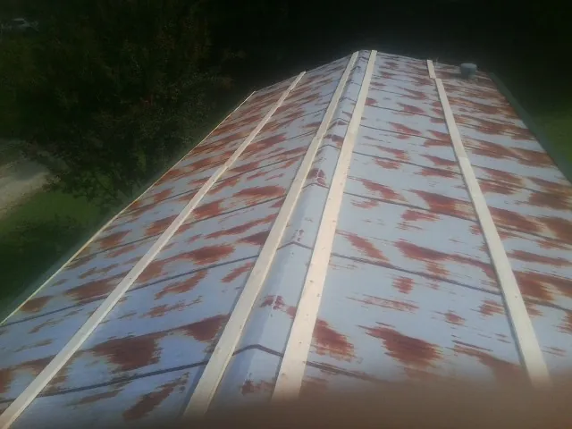 Rusted metal roof panels with new wood purlins before replacement — Storm Damage Roof Repair in Mc Clure by Roofing Brothers
